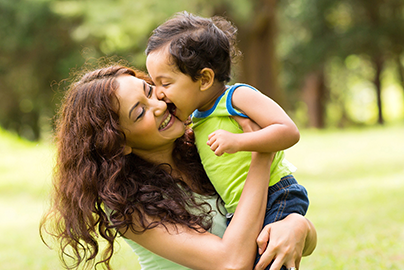 Mother and toddler son playing outside.