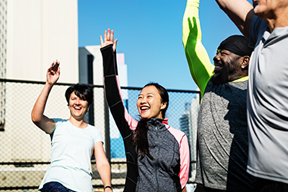 Group of people with their hands raised, smiling.