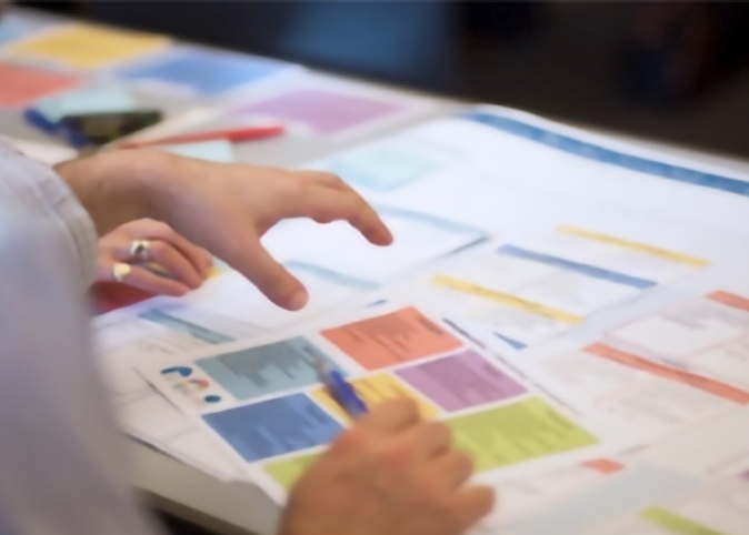 closeup of person's hands gesturing at papers spread on a table