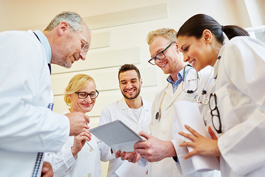 Doctors around iPad (c) Adobe Stock. All rights reserved.