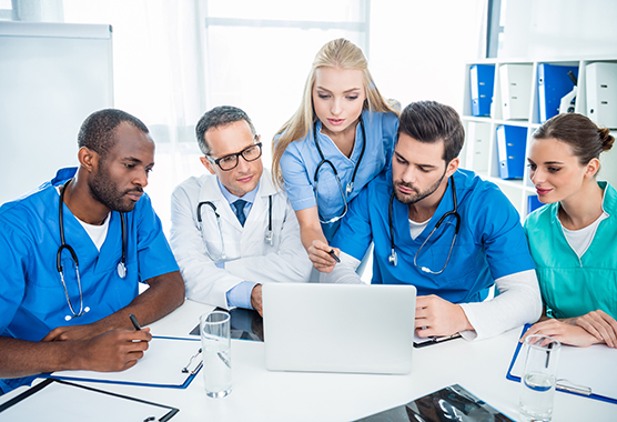 Doctors around table (C) Adobe stock. All rights reserved.