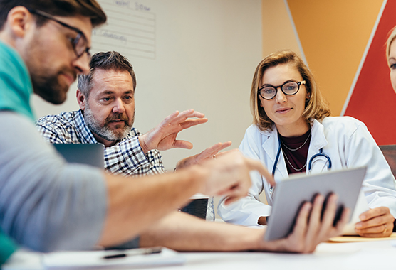 Educators at tablet (C) Adobe stock. All rights reserved.