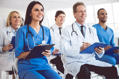 Clinicians writing at a conference. (C) Adobe Stock. All rights reserved.