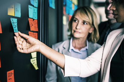 Two people looking at a wall with sticky notes. (C) Pixabay. All rights reserved.