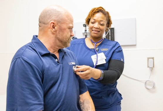 Female nurse listening to the heart of a male patient