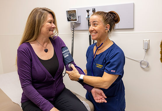 Older woman and a younger woman talking to a physician in the clinic