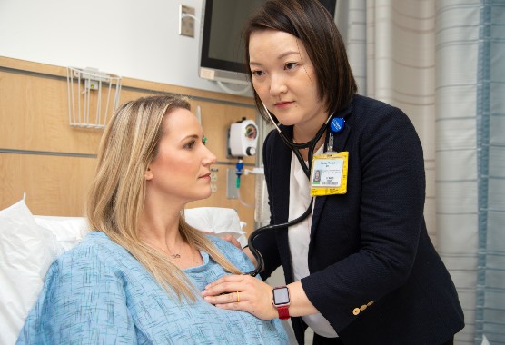 Female physician listening to the heart of a female patient