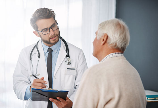 Male physician talking to male patient in a clinic