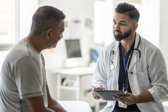 Male provider talking to a male patient in a health care clinic.