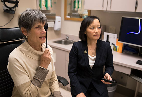 Female patient receiving an eye exam and a female provider sits beside her