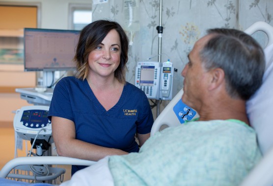 Female nurse looking at male patient in a hospital bed as he speaks