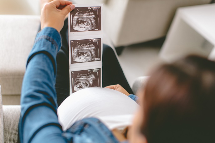 Pregnant woman looking at the ultrasound of her baby