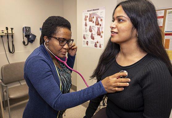 Heart doctor listening to female patient’s heart to check for heart disease.