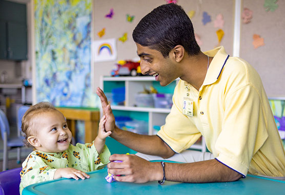 Young patient high fiving a hospital volunteer