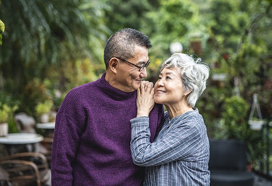 Older couple embracing and looking at each other lovingly.