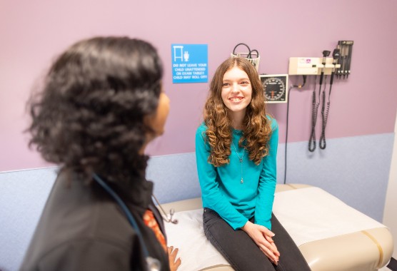 A pediatric female patient in an exam room with a female physician