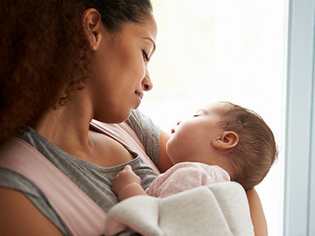 Mom looking down at baby she's holding