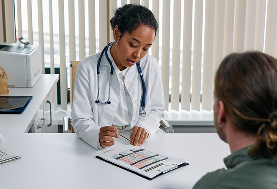 Female health care worker explaining what’s on a paper to a patient.