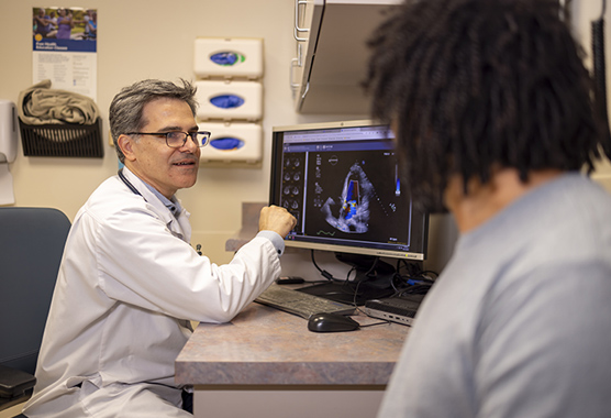 Heart doctor showing scan to patient with structural heart disease.