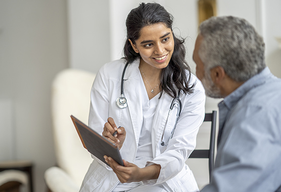 Health care provider talking to male patient in clinic.