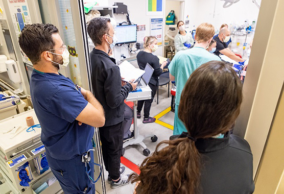 Emergency providers tending to a patient in a hospital room