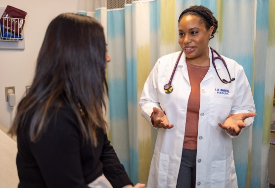 Female physician speaking to her female patient and smiling