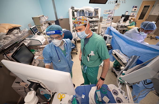 Two health care providers looking at computer screen during procedure