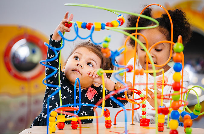 Two young girls playing with toys