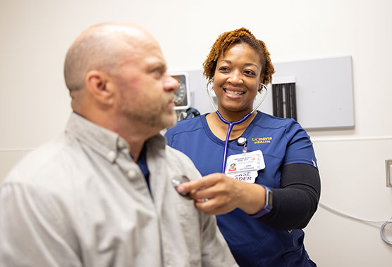 Female nurse listening with a stethoscope to male patient’s heart in a medical clinic 