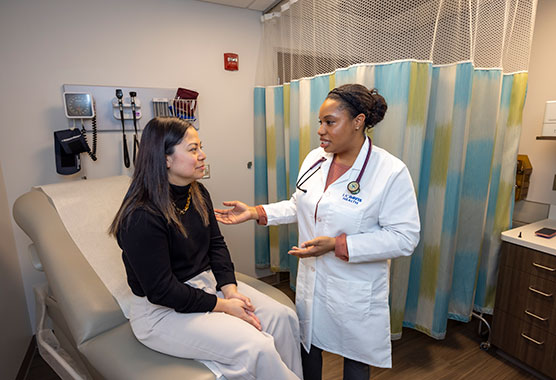 Female provider talking to female patient in an exam room