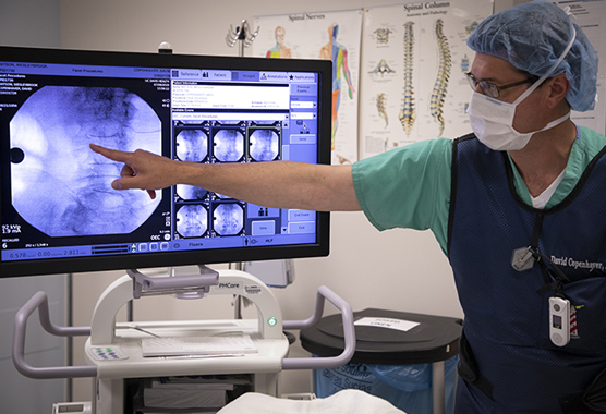 Pain medicine provider looking at images on a screen.