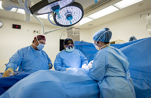 Surgeons operating on patient in surgery room.