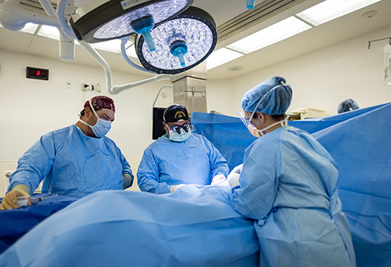 Surgeons performing brain tumor surgery in operating room.