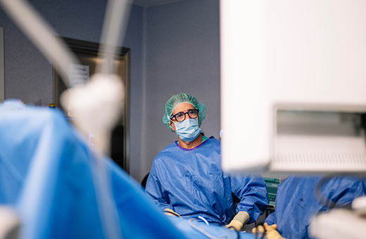 Surgeon performing burn surgery on patient in operating room.
