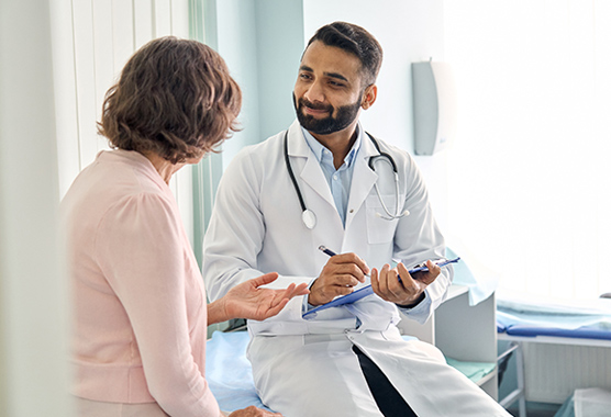 Colorectal surgeon talking to female patient about surgery in clinic.