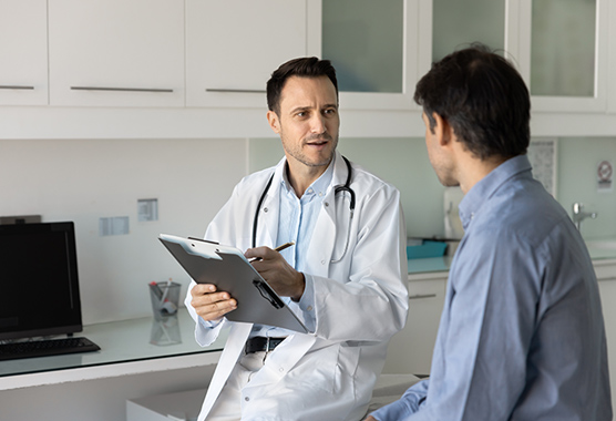 Health care provider discussing GI surgery with patient in a clinic.