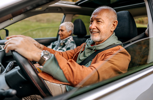 Man driving a car with a woman sitting in the passenger.