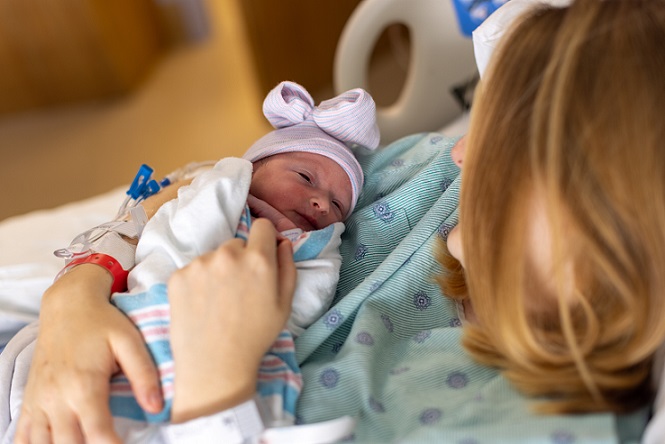 Mother holding newborn baby after giving birth