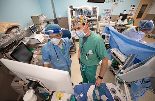 Two health care providers discussing during surgery to relieve pain.