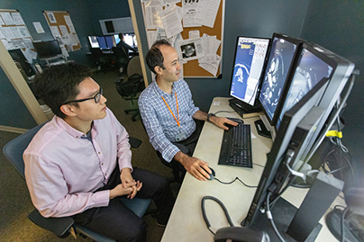 Two providers looking at scans on a computer