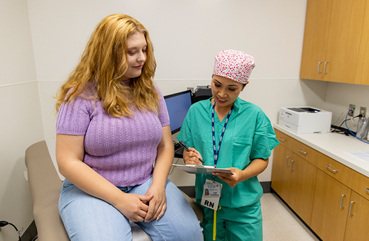 Female health care provider explaining information on a paper to female patient.