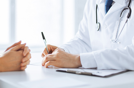 Health care provider sitting at a desk discussing neurospychological test results with patient.
