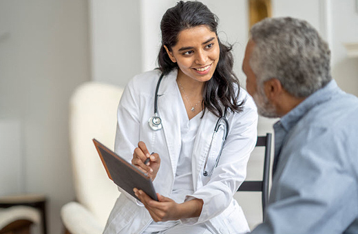 Female provider and male patient looking at paperwork on a clipboard.