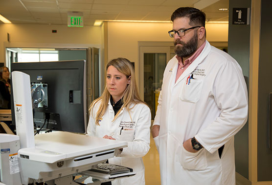 Male and female health care providers looking at a computer screen