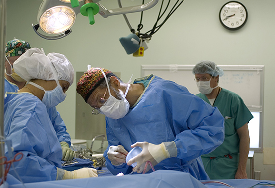 Neurosurgeon performing pain neurosurgery on patient.