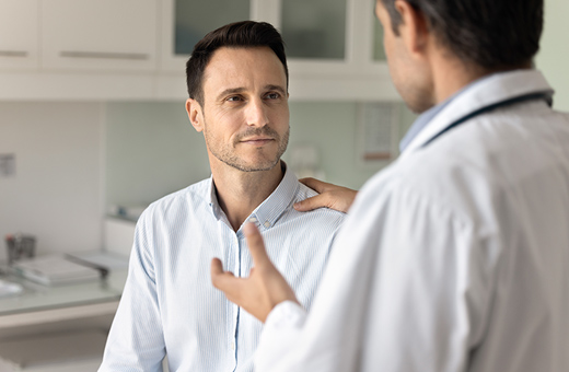 Health care provider talking to male patient after peripheral nerve surgery.