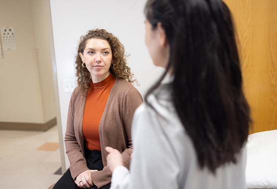 Health care provider talking to female patient before peripheral nerve surgery.