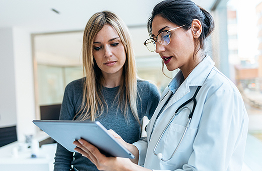 Female patient and physician talking in clinic.