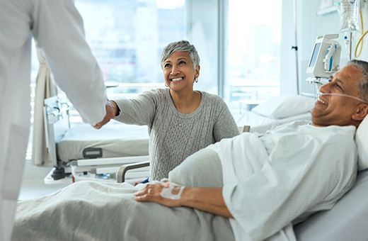 Male patient and female family member talking to doctor after TAVR.