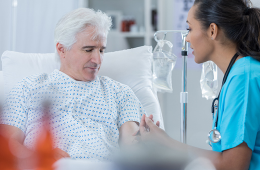 Male patient getting IV from nurse before TAVR.